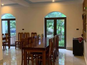 峰牙Phong Nha Moonlight Villas的一间带木桌和椅子的用餐室