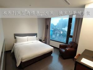 平镇日月光国际饭店桃园馆的卧室配有床、椅子和窗户。