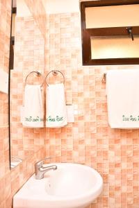基苏木Divine Homes Resort Kisumu的浴室配有水槽和墙上的毛巾