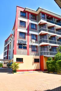 基苏木Divine Homes Resort Kisumu的街上高大的红白色建筑
