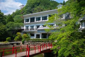 姬路Yumoto Ueyama Ryokan的一座河上桥梁上的建筑物