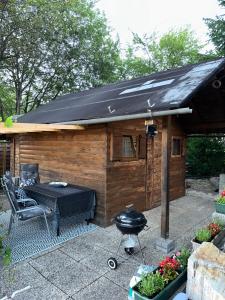 Ferienhaus_natikrausz的木制棚屋前的烧烤架