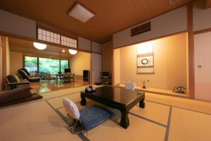 姬路Yumoto Ueyama Ryokan的一个带桌椅的大客厅