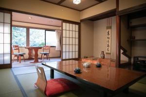 姬路Yumoto Ueyama Ryokan的一间带桌椅的房间和一间用餐室