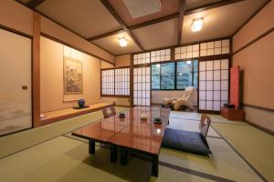 姬路Yumoto Ueyama Ryokan的客厅配有桌椅和窗户。