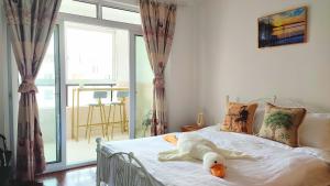 上海LI的家的一只白泰迪熊躺在卧室的床上