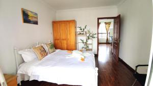 上海LI的家的卧室配有白色床单和白色床。