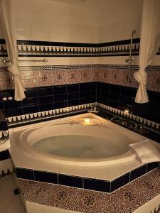 伊斯费古耶拉尔海滩恩卡特德尔里约庄园公寓的浴室设有黑色瓷砖和大浴缸。