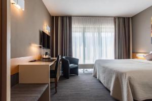 梅赫伦梅赫伦霍比特酒店的配有一张床和一张书桌的酒店客房