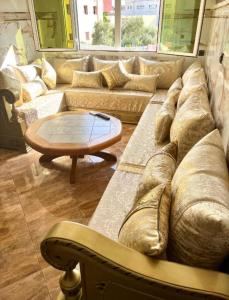纳祖尔Nador cornich Apartement的客厅配有大沙发和桌子