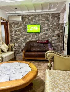 纳祖尔Nador cornich Apartement的客厅配有真皮沙发和电视