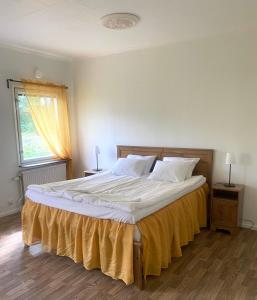GullringenGullringens Värdshus & hotell的卧室配有一张带白色床单的大床和窗户。