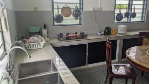 拉布安Ayana Homestay的厨房配有水槽和带锅碗瓢盆的台面