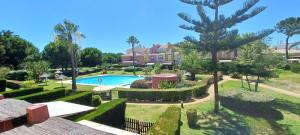 伊斯兰蒂拉Adosado en Islantilla的享有带游泳池和树木的别墅的正面景色