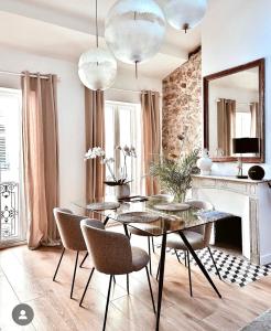 昂蒂布L appartement de Manon, centre historique du vieil Antibes的一间带桌椅和壁炉的用餐室