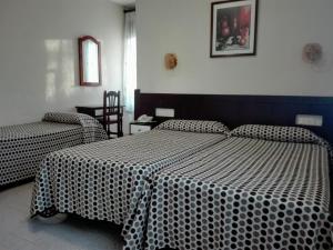 隆达皇家酒店的一间卧室配有两张黑白床单