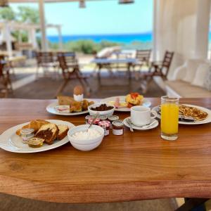 艾拉方索斯Elafonisos Mare的餐桌上摆放着早餐食品和橙汁盘