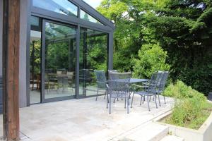 伯多兹Ferienhaus mit eigenem Garten und Terrasse的庭院配有椅子和桌子及玻璃门