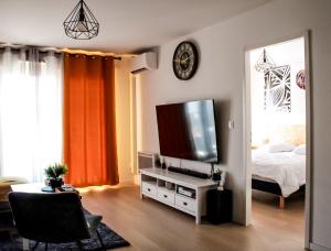 蒙彼利埃Appartement nouveaux quartier Bologne à deux pas de Mosson, WiFi, climatisation et parking gratuit的客厅配有床和平面电视