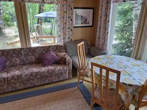 Lakeside Hilda, rantamökki的客厅配有沙发和桌子