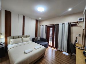 Ban Huai KrathaekLeMae Residence เลอเม เรสซิเดนซ์ อำเภอเขาย้อย เพชรบุรี的一间卧室配有一张床、一张沙发和一个窗口