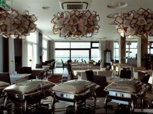 梅尔诺Baltivia Sea Resort的餐厅设有桌椅和吊灯。