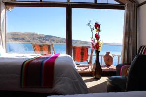 普诺Titicaca Aruntawi Lodge Peru的一间卧室配有床和花瓶