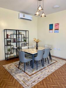 马斯喀特Deluxe Apartment的一间位于地毯上的带桌椅的用餐室