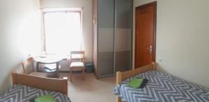 RaganaJaunvaltes的小房间设有两张床、一张桌子和一扇窗户