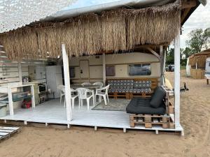 切尔诺莫雷茨Beach hub caravans Gradina的海滩上带桌椅的小屋