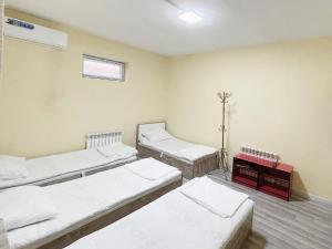塔什干Stay hostel的一间设有三张床的房间,设有窗户