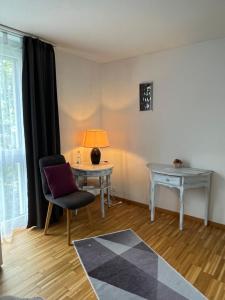 克罗伊茨林根Oasi 2的客厅配有桌子、椅子和灯