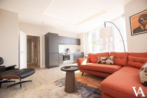 利兹Velvet Apartments - 56 Vicar Lane的客厅配有橙色沙发和桌子