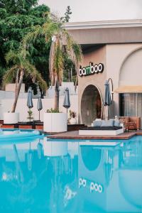 伊利索斯Bamboo Suites Hotel的大楼前设有游泳池的酒店