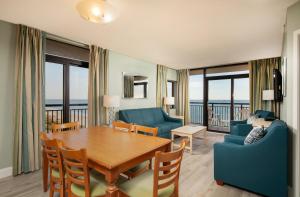默特尔比奇大海岸海洋度假公寓式酒店的客厅配有桌椅和沙发