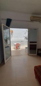 苏塞Chouette villa au bord de la plage hergla的一间设有一扇开放式门的客房,享有海滩美景