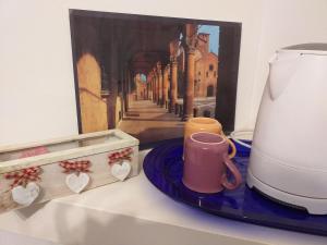 博洛尼亚L'Appartamentino的咖啡壶和画作柜台上的杯子