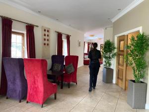罗斯康芒汉伦斯酒店的一位女士在走廊上用红色和紫色椅子行走