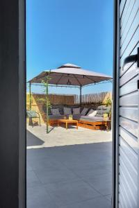 海若克利欧Holiday House Heraklion & Roof Garden的一个带桌子和遮阳伞的庭院