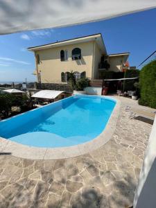 阿尔比索拉马里纳Casa Milena elegante dimora con piscina privata的一座大蓝色游泳池,位于房子前