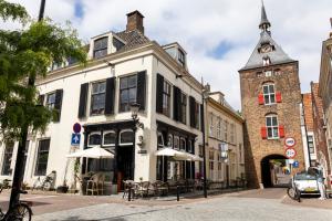 菲亚嫩Luxe en ruim appartement in Rijksmonument的街道上一座白色的建筑,有钟楼
