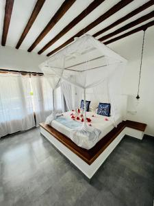 南威MITI Beach Bungalows的一间卧室配有一张带天蓬的白色床