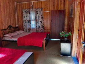 BhogweVamoose Manali Beach Resort的一间卧室配有一张带红色毯子的床