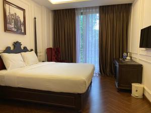 土龙木市Feliz Hotel Binh Duong的酒店客房设有一张床和一个大窗户