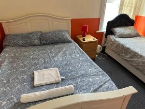 滨海绍森德Malvern Lodge Guest House- Close to Beach, Train Station & Southend Airport的一间卧室配有两张床和一个带灯的床头柜