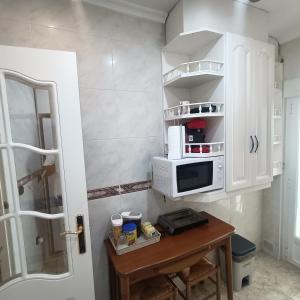 萨拉曼卡Luxury Family Homes K的厨房配有微波炉和木桌