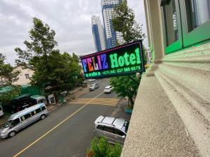 土龙木市Feliz Hotel Binh Duong的一辆汽车停在街上的酒店标志