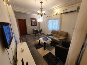 杜阿拉Résidence M Douala的客厅配有沙发和桌子
