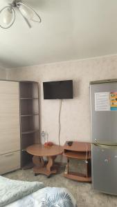 卡缅斯科耶" Na golubom ozere"的一间设有桌子的房间和墙上的电视