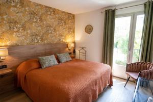 圣雷米普罗旺斯拉曼迪艾尔酒店的一间卧室设有一张床和一个大窗户